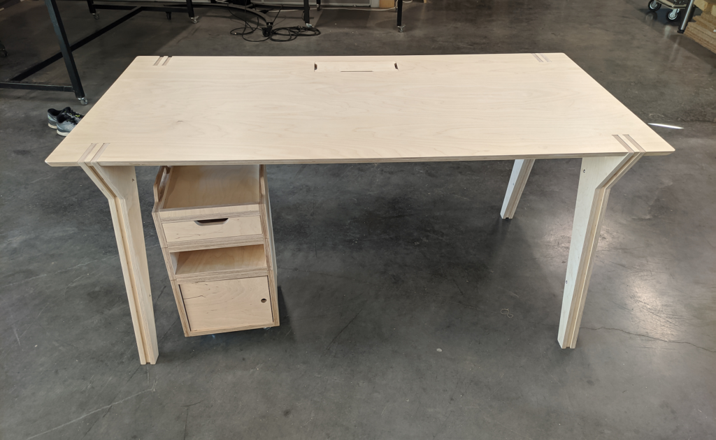 Une photo d'un bureau et d'un meuble de rangement en contreplaqué de bouleau